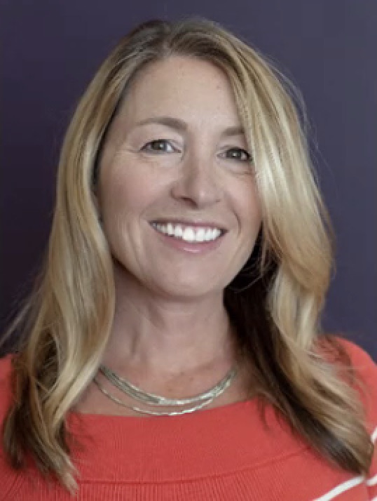 Portrait of a woman with long blonde hair and a warm smile.